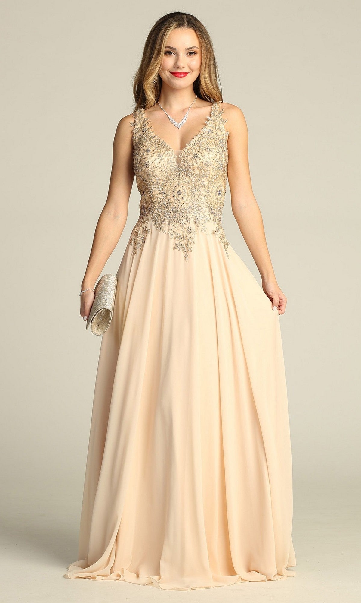 Wearing the Long Formal Dress: Chicas DM4006, which features a sleeveless design with an embroidered bodice and a flowing chiffon A-line skirt, a woman stands against a plain background holding a clutch and wearing a necklace.